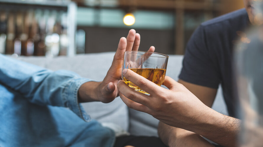 Ein alkoholisches Getränk wird in enger Runde abgelehnt Ein alkoholisches Getränk wird in enger Runde abgelehnt